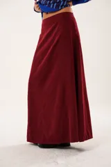 Falda larga color borgoña, confeccionada en tela suave con acabado tipo piel de durazno y cierre invisible lateral.