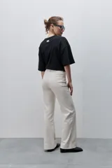 Pantalón de jean azul marino, de tiro alto y calce ajustado con pierna recta levemente amplia, bolsillos traseros y recortes verticales en el delantero.
