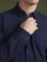 Camisa de hombre color azul marino, de piqué con cuello abotonado y manga larga.