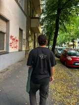 Remera negra oversize con cuello redondo y estampado pequeño en el pecho.