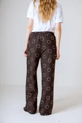 Pantalón de vestir negro con estampado de círculos blancos, corte holgado y tiro alto.