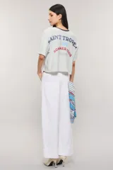 Remera boxy de algodón con estampado de rayas celestes sobre fondo blanco, cuello redondo oscuro y mangas cortas.