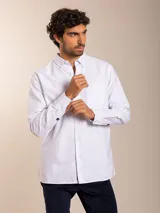 Camisa blanca de corte clásico con cuello abotonado, manga larga y bolsillo en el pecho.