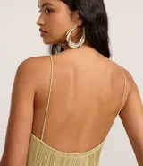 Vestido midi de jersey texturizado color verde oliva, con escote halter, espalda descubierta, breteles finos y tajo lateral.