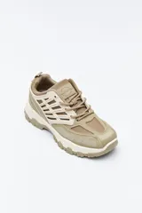 Zapatilla deportiva de estilo trekking con diseño técnico y urbano. Presenta una estructura combinada de paneles de malla y piezas de poliuretano, con sistema de cordones integrado y suela robusta con relieve para mayor estabilidad.