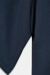 Camiseta de cuello barco y manga larga con diseño asimétrico en el bajo. Presenta un corte entallado con cierre lateral mediante cremallera oculta.