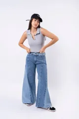 Top sin mangas de tejido acanalado, color negro, con cuello polo abierto y escote pronunciado en V. Presenta un pequeño parche con inscripción en el bajo.