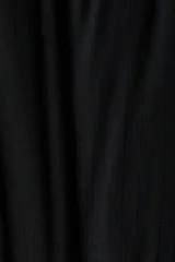 Pantalón de pijama de punto pointelle suave, de color negro, con piernas levemente acampanadas, cintura elástica con ribete de volados y cordón de ajuste.