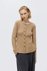 Saco de punto acanalado con cuello redondo, cierre frontal con botones y diseño de peplum con vuelo en la cintura.