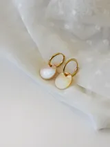 Par de aros dorados con forma de argolla, con dije circular de nácar.