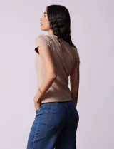 Remera color beige de tejido acanalado, con escote a la base y manga corta.