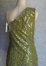 Vestido corto ajustado color verde lima, con escote pronunciado en V tipo drapeado y tirantes finos. El vestido está cubierto de lentejuelas plateadas.