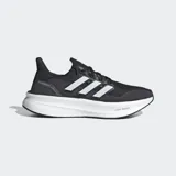 Championes de running Adidas Ultraboost 5, color negro con tres franjas laterales blancas. Cuentan con mediasuela blanca con tecnología Light BOOST V2 y refuerzo de talón externo moldeado.