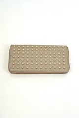 Billetera rectangular dorada con cierre perimetral y diseño de tachas metálicas en toda la superficie frontal.