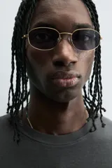 Sudadera sin mangas (tipo chaleco) de color gris oscuro con efecto lavado, corte relajado y cuello redondo. Presenta un estampado frontal en color rosa neón con texto y gráficos abstractos.