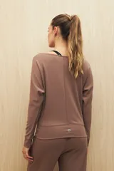 Buzo color beige de calce fluido, con cuello bote y mangas murciélago.