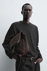 Camiseta de manga larga con corte relajado, confeccionada en tejido compacto de algodón. Presenta cuello redondo acabado en rib y detalle de costura central en la espalda.