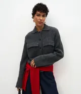 Campera de punto gris oscuro con textura suave, cuello clásico, cierre frontal con botones y dos bolsillos aplicados con solapa en el pecho.