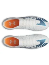 Championes de fútbol Under Armour Shadow Elite 4 Mach FG, color blanco con detalles en azul y naranja. Presentan una placa de fibra de carbono optimizada para mayor agilidad, microtextura háptica 3D en el empeine para un contacto óptimo con el balón y cuello elástico de punto para un ajuste ceñido.