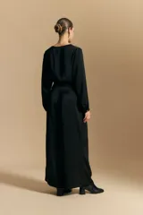 Pantalón ancho de tiro alto color marrón oscuro, con pinzas en la cintura, cinto incorporado y silueta fluida.