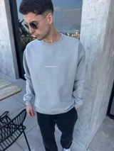 Buzo de algodón con calce oversize, cuello redondo y puños acanalados. Presenta un bordado minimalista con el logo de la marca en el centro del pecho.