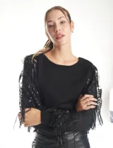 Buzo de tejido negro con mangas largas de microtul transparente, decoradas con bordados de lentejuelas y flecos brillantes. Presenta un diseño elegante con cuello redondo.