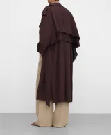 Gabardina oversize color marrón oscuro, con diseño cruzado, solapas grandes, mangas largas con trabilla en los puños, bolsillos delanteros y cinturón ajustable del mismo tejido.