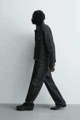 Pantalón jeans de corte recto y ajuste holgado, confeccionado en denim de algodón rígido. Presenta diseño clásico de cinco bolsillos, cierre frontal con cremallera y botón, con un acabado de lavado claro.