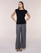 Buzo sin mangas de punto fino color beige, con calce al cuerpo y escote volcado estructurado con solapa superpuesta en el pecho.