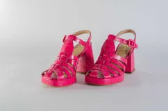 Sandalias de cuero fucsia con tiras tipo gladiadora, plataforma y taco cuadrado. Cierre con hebilla al tobillo.
