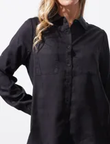 Camisa color verde oliva de lyocell, marca Cyrus. Tiene cuello con solapa, abertura central con botones, mangas 3/4 regulables con presilla y botón, y dos bolsillos delanteros aplicados.