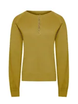 Sweater de punto color mostaza, con cuello redondo y cierre frontal parcial con botones de madera. Presenta mangas largas con puños ajustados y un corte regular.