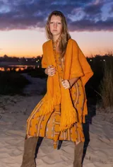 Ruana color maíz confeccionada en lana merino, de tejido suave y ligero con flecos en el borde inferior.