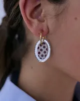 Dije colgante ovalado de acrílico espejado con borde festoneado y centro de resina con estampado de lunares.