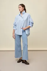 Jean de tiro alto y diseño wide leg con perneras amplias, en color celeste claro, de estilo clásico con cinco bolsillos.