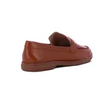 Mocasines de cuero color caramelo, con detalle de vincha en el empeine con estoperol metálico dorado y suela baja de goma.