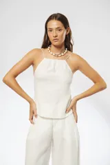 Top blanco de lino con breteles finos elásticos regulables en la espalda y fruncido en el escote y la espalda.