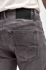 Jean de corte slim, color gris con efecto lavado, confeccionado en denim con cierre frontal y bolsillos laterales.