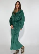 Chaqueta azul marino de terciopelo con cuello camisero, cierre frontal con botones, dos bolsillos de parche con solapa y mangas largas con puños abotonados.