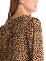 Blusa de gasa con estampado animal print, cuello a la base con escote en V y cierre frontal, manga larga con puños elastizados.