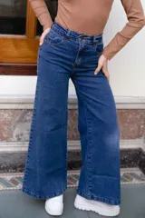 Jean de tiro alto y corte wide leg en tono azul medio, con bolsillos delanteros y traseros.