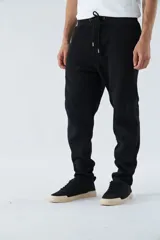 Pantalón deportivo de invierno, corte clásico con bolsillos laterales y cintura elástica con cordón ajustable. Presenta logo estampado y detalle en goma.