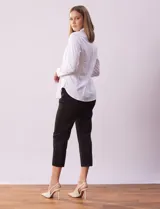 Camisa blanca de algodón con cuello con solapa, abertura central con botones y mangas largas con puño y botón.