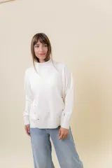 Sweater de tejido de punto color marrón, con cuello alto, corte relajado y terminaciones en rib en puños y cintura. Presenta una hilera de botones metálicos decorativos en uno de los laterales.