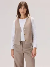 Chaleco negro sin mangas, de corte recto y largo a la cintura, con cuello redondo y cierre frontal oculto.