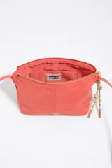 Bolso bandolera mini de Bimba y Lola en color negro, con cierre de cremallera superior, asas cortas de mano y tirador decorativo de cuerda con cuentas rojas. Presenta el logotipo de la marca impreso en letras doradas en la parte frontal.