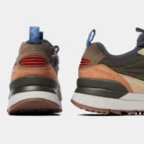 Championes Merrell modelo Alpine 83, con diseño inspirado en el senderismo retro. Presentan una combinación de gamuza y tela en tonos verde oliva, beige y marrón, con suela de goma y cordones técnicos.