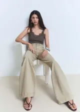 Pantalón de jean estilo wide leg de tiro alto, con cierre de cremallera y botón, y bolsillos traseros.