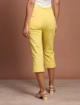 Pantalón capri blanco de gabardina elastizada. Pretina ancha elastizada, delantera con bolsillos simulados y trasera con bolsillos aplicados.
