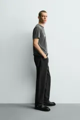 Camiseta de corte slim fit, cuello redondo y manga corta, color gris oscuro con efecto lavado. Presenta un gran estampado frontal con el número "74" en blanco desgastado y pequeños estampados circulares en los hombros.